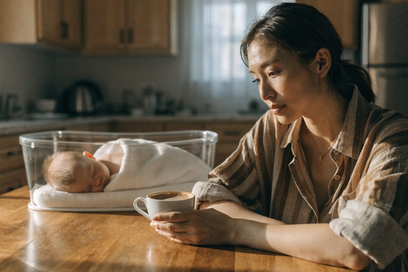 madre revisando información sobre alcohol y cafeína mientras sostiene una taza