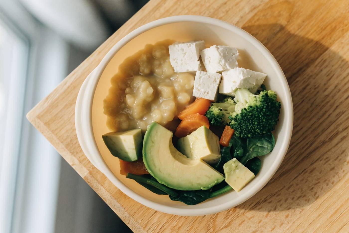 plato de comida vegetariana para bebé con legumbres, palta y cereales