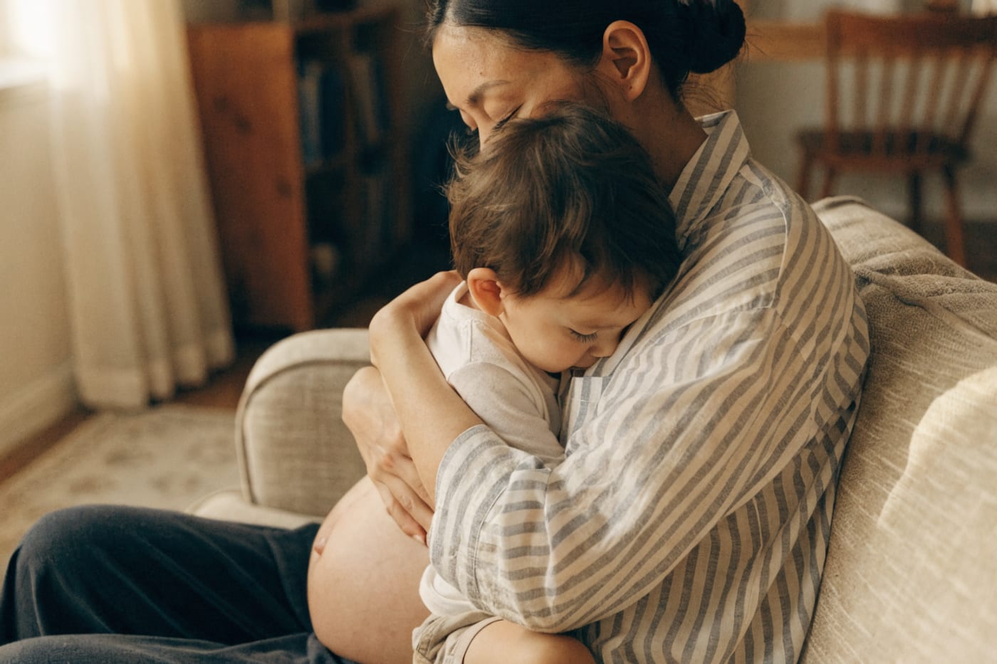 madre amamantando a su hijo mayor con la guatita de un nuevo embarazo