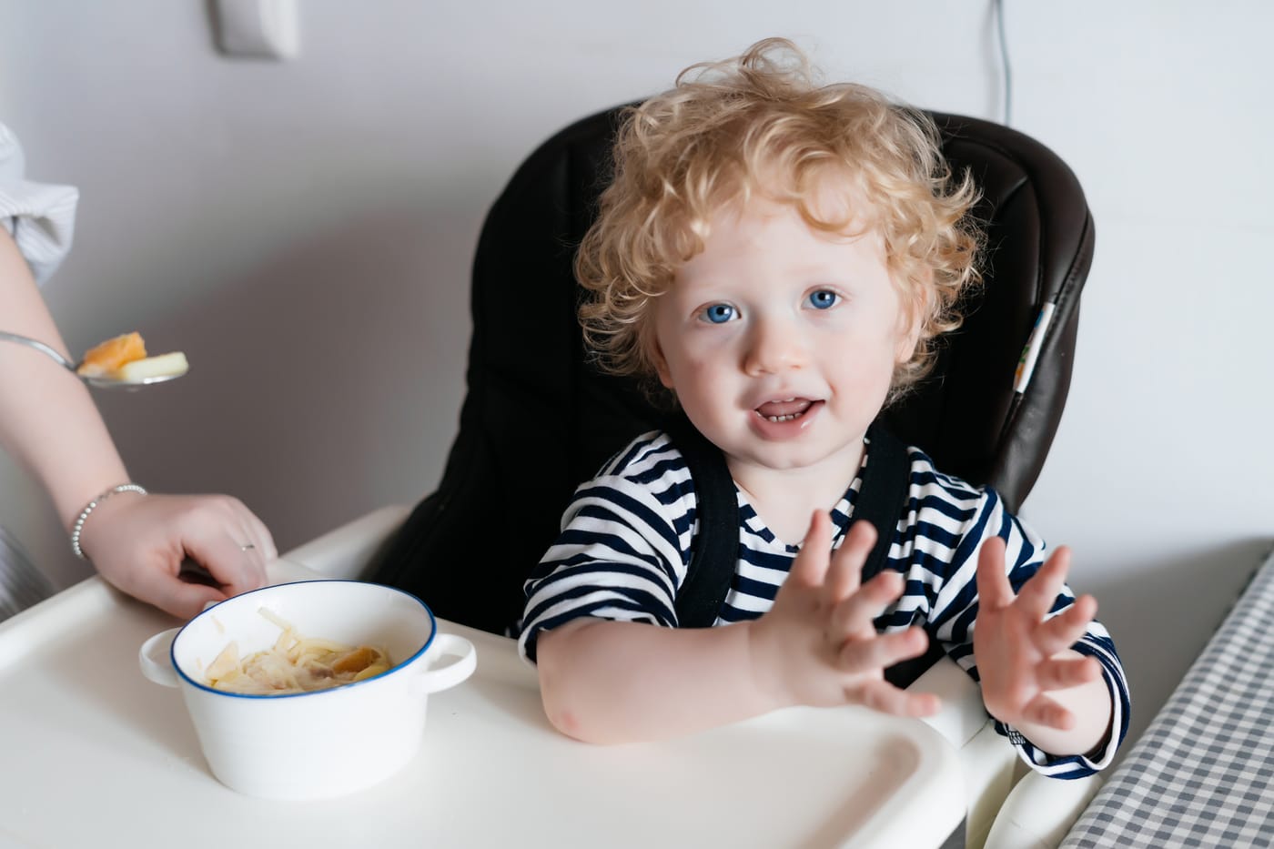 bebé sentado mostrando interés por un plato de comida