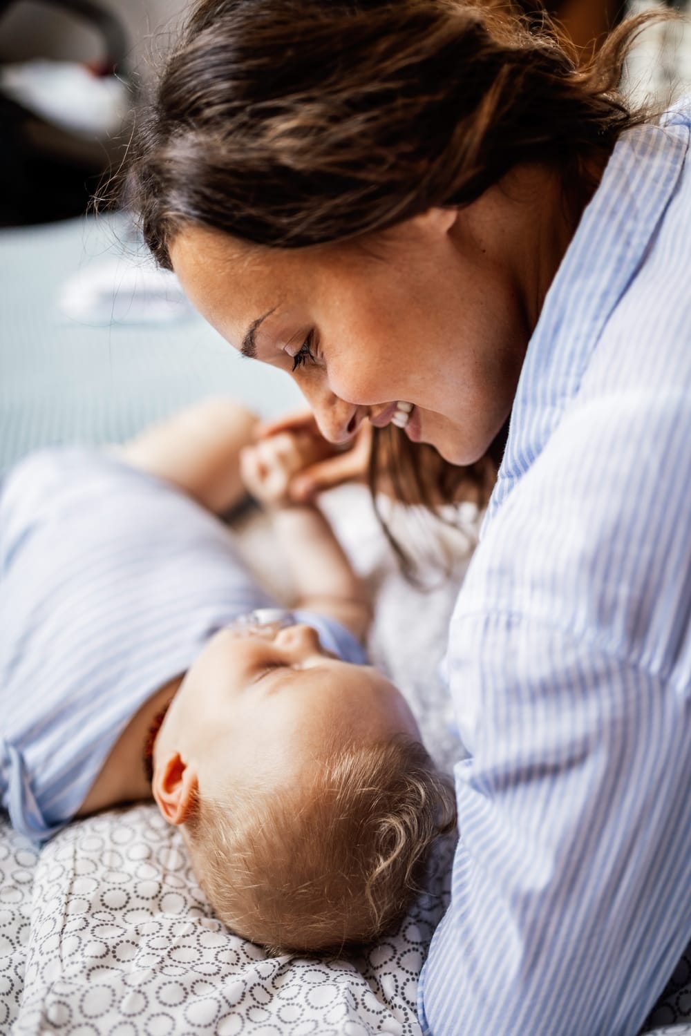 Madre sonriendo con ternura junto a su bebé recién nacido, el punto de partida de esta historia